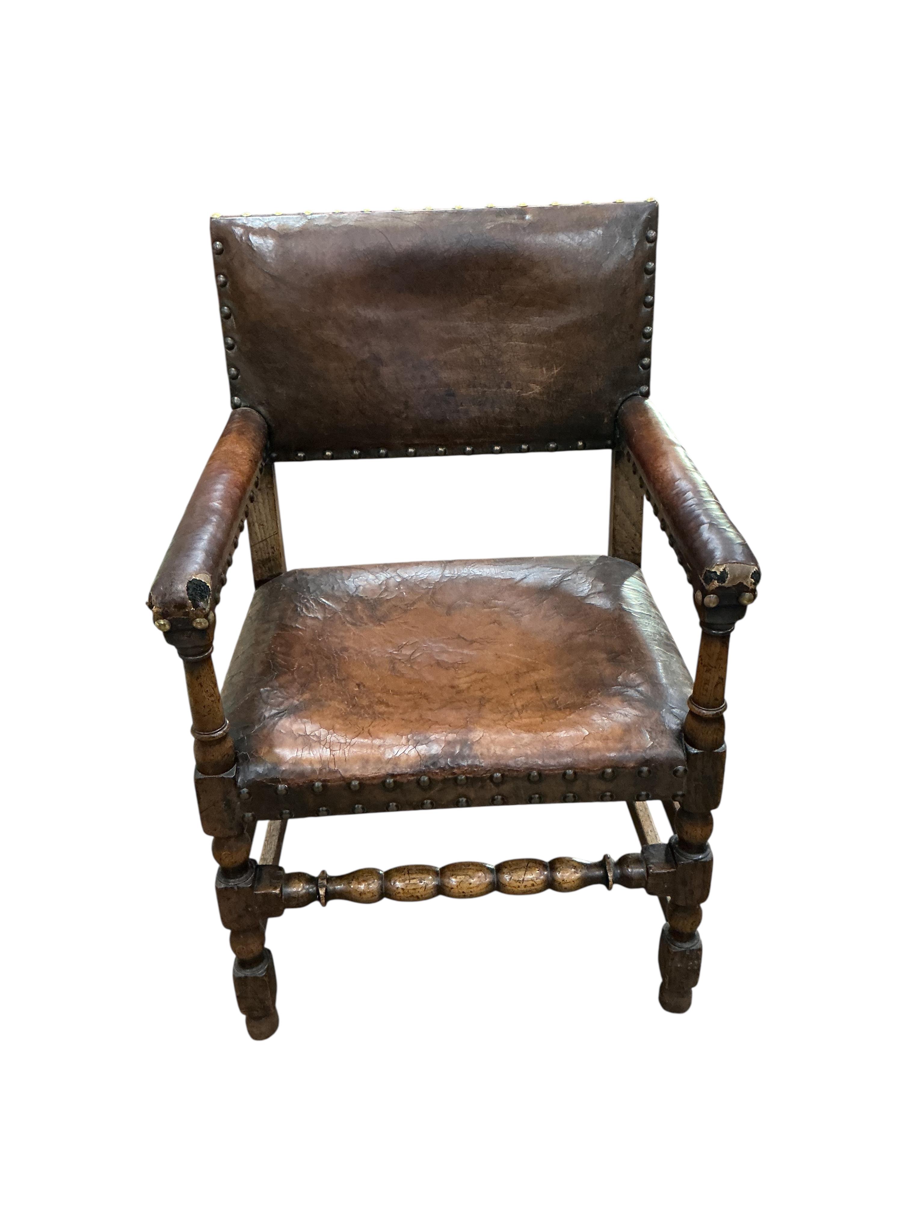 A set of eight Cromwellian style oak and tan leather dining chairs, two with arms
